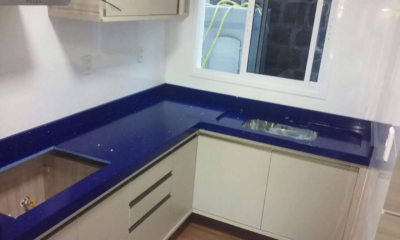 Bancada de cozinha em quartzo azul-cobalto com armários brancos
